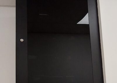 Baie informatique murale fermée avec porte vitrée fumée installée pour une petite entreprise