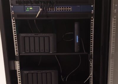 Baie informatique murale équipée d’un switch, d’une box internet et de deux NAS