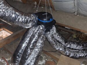 Caisson VMC Aldes suspendu en combles avec gaines souples isolées aluminium raccordées.