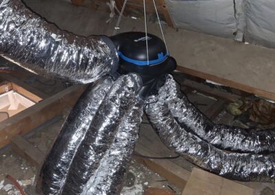 Caisson VMC Aldes suspendu en combles avec gaines souples isolées aluminium raccordées.