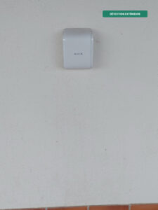 Détecteur de mouvement extérieur Ajax DualCurtain Outdoor bidirectionnel installé en façade, détection type rideau avec immunité animaux