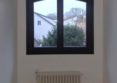 Entrée d’air autoréglable Anjos 22 m³/h installée sur coffrage de volet roulant en chambre.